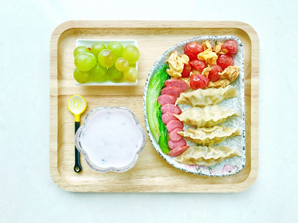 food on ceramic plates on square wooden tray