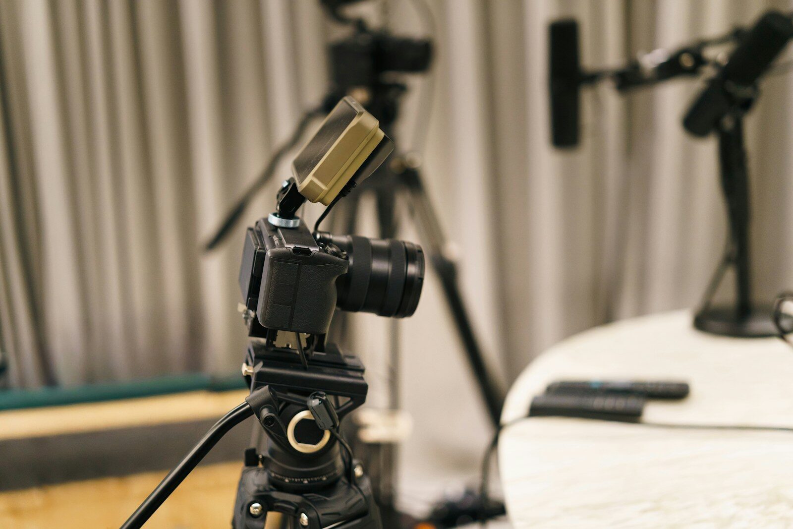 Camera on tripod with microphones in background
